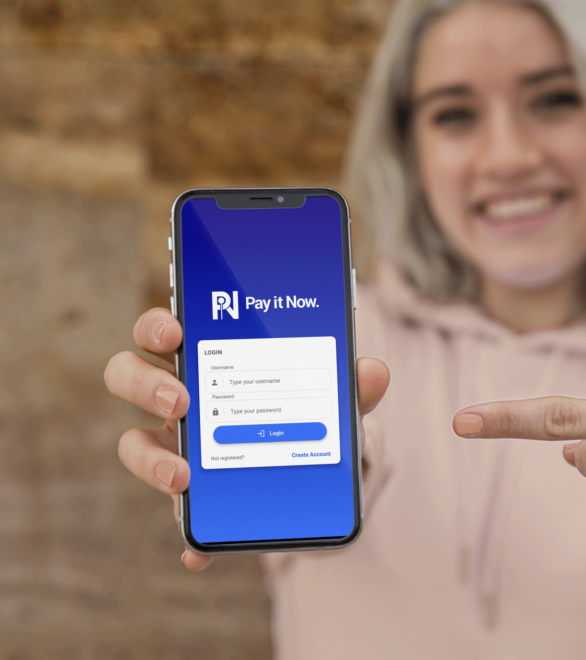 A woman holding her phone towards the camera, showing the PIN App on the screen.